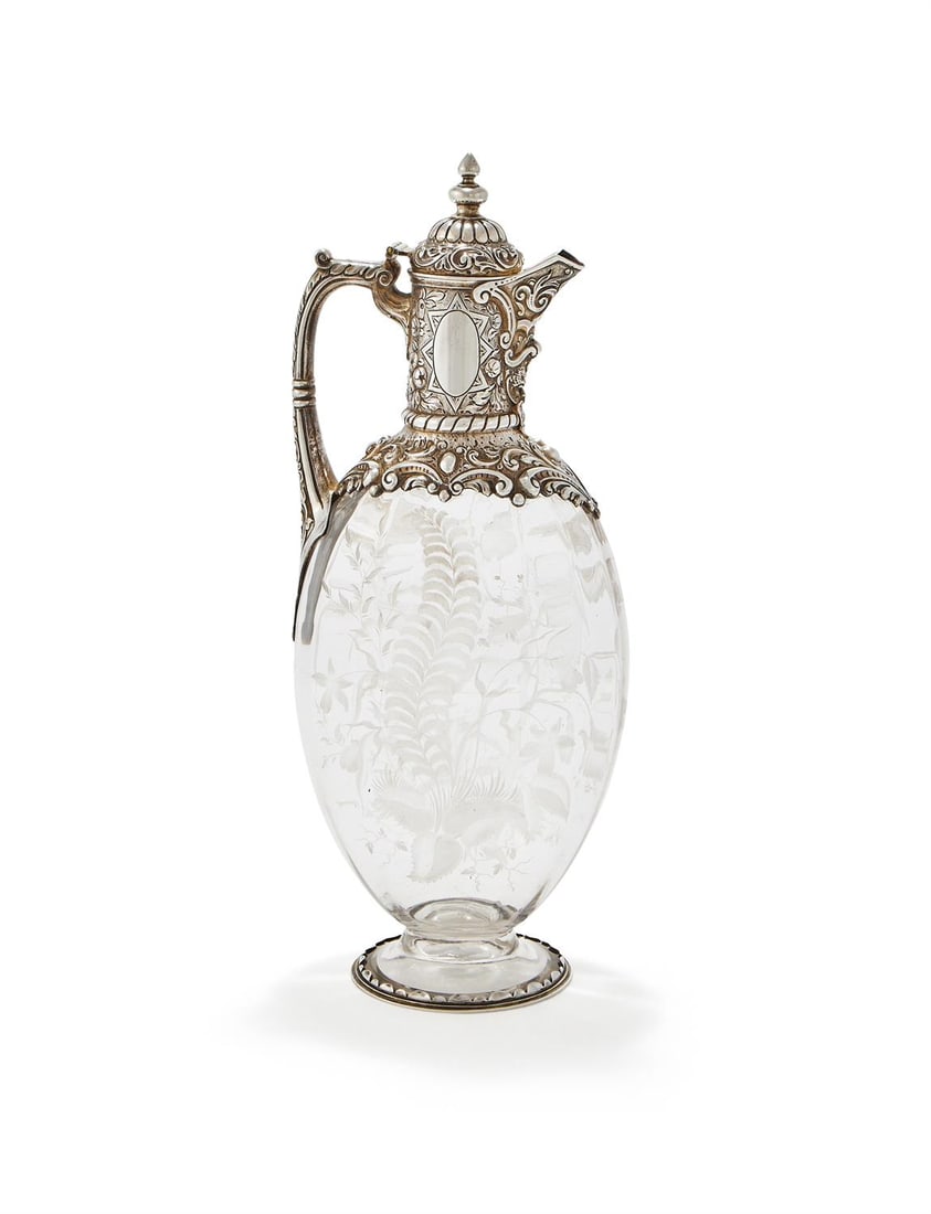 A VICTORIAN PARCEL GILT SILVER MOUNTED STOURBRIDGE GLASS CLARET JUG: A VICTORIAN PARCEL GILT SILVER MOUNTED STOURBRIDGE GLASS CLARET JUGCHARLES EDWARDS, LONDON 1888 With a cone finial to the domed cover, a leaf capped handle, chased with floral sprays, C-scrolls and a