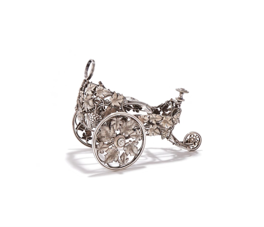 CHRISTOFLE, A FRENCH SILVER PLATED WINE BOTTLE CHARIOT: CHRISTOFLE, A FRENCH SILVER PLATED WINE BOTTLE CHARIOTPARIS, LATE 19TH CENTURY, NO. 1120688On three wheels with grape vine decoration31cm long