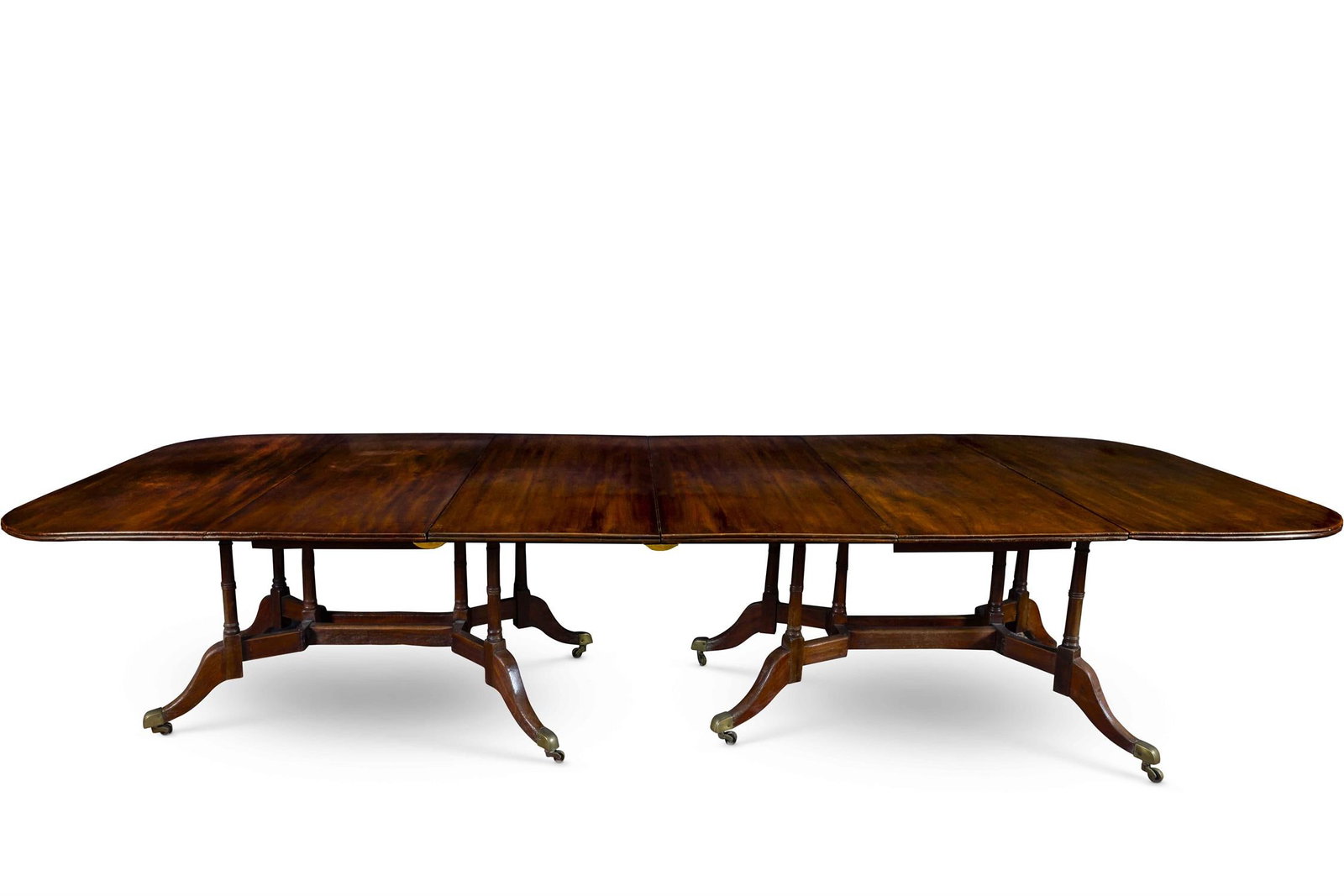 A GEORGE III CUMBERLAND-ACTION DINING-TABLE, LATE 18TH CENTURY: A GEORGE III CUMBERLAND-ACTION DINING-TABLELATE 18TH CENTURYEach rounded rectangular end with a drop leaf and two additional leaves, on turned, gate-leg supports with sabre legs and brass capped casto