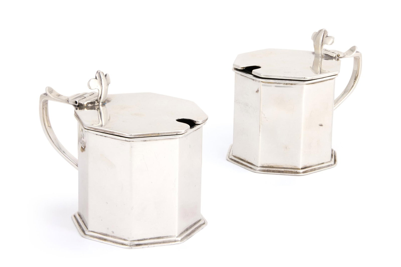A PAIR OF SILVER BRITANNIA STANDARD OCTAGONAL MUSTARD POTS: A PAIR OF SILVER BRITANNIA STANDARD OCTAGONAL MUSTARD POTSCRICHTON BROTHERS (LIONEL ALFRED CRICHTON), LONDON 1929With trefoil thumb pieces to the flat covers and scroll handles7cm high336g (10.8 oz) W