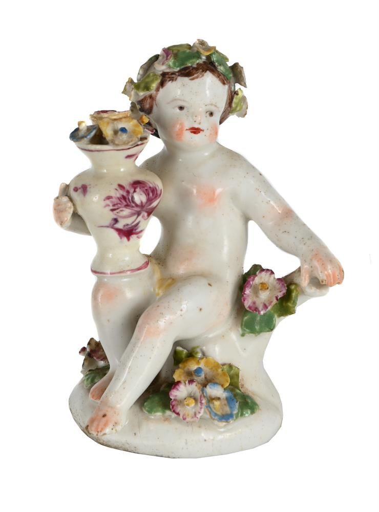A BOW PORCELAIN MODEL OF A PUTTO, MID 18TH CENTURY: A BOW PORCELAIN MODEL OF A PUTTO MID 18TH CENTURY Modelled seated with a vase issuing flowers 10cm high, 5cm at base Condition Report: PLEASE NOTE: ALL