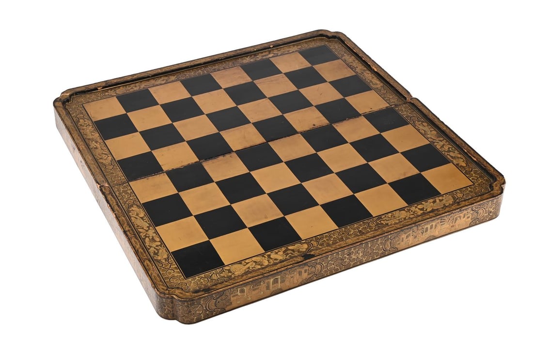A CHINESE EXPORT BLACK AND GOLD LACQUER CHESS AND BACKGAMMON BOARD, FIRST HALF 19TH CENTURY: A CHINESE EXPORT BLACK AND GOLD LACQUER CHESS AND BACKGAMMON BOARD FIRST HALF 19TH CENTURY the hinged box with landscapes and painted stylised flower, butterfly and precious object