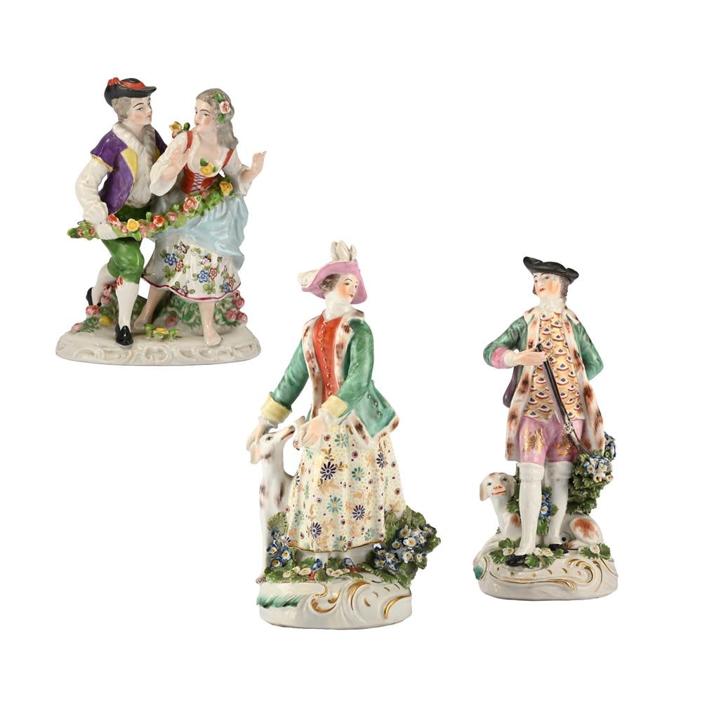 A PAIR OF DERBY FIGURES OF A SPORTSMAN AND HIS COMPANION, CIRCA 1770, TOGETHER WITH ANOTHER: A PAIR OF DERBY FIGURES OF A SPORTSMAN AND HIS COMPANION CIRCA 1770 Modelled standing on flower encrusted bases 23.5cm high and marginally smaller, 9cm at base TOGETHER