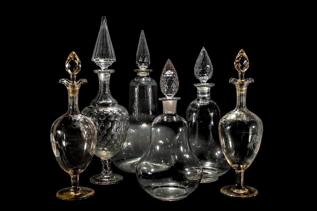 FOUR VARIOUS CLEAR GLASS CHEMIST JARS AND FACETED STOPPERS, TOGETHER WITH A PAIR OF DECANTERS: FOUR VARIOUS CLEAR GLASS CHEMIST JARS AND FACETED STOPPERS the largest 76cm high and the smallest 58cm TOGETHER WITH A pair of large pale yellow tint pedestal decanters and stoppers,