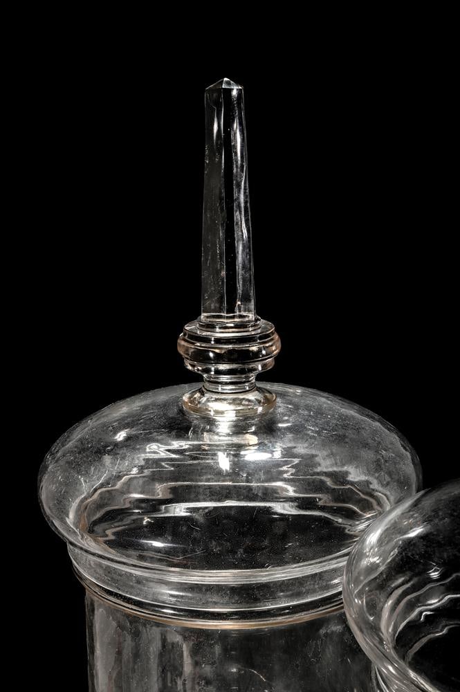 A PAIR OF CLEAR GLASS PEDESTAL CHEMIST JARS AND COVERS - 2