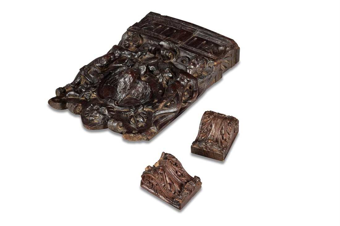 A CARVED OAK PANEL, EARLY 17TH CENTURY, TOGETHER WITH A PAIR OF CARVED OAK SMALL CORBELS: A CARVED OAK PANEL EARLY 17TH CENTURY Fluted frieze above bird in flight within cartouche, flanked between two putti figures, lion mask below 39cm high, 29cm wide 