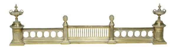 A Victorian brass fender , circa 1880, with urn fi