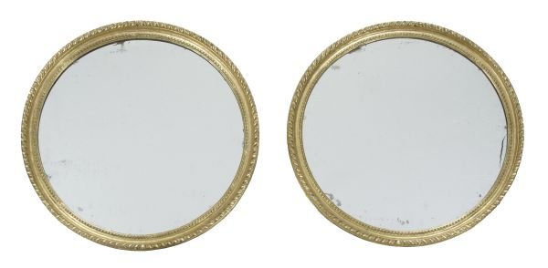 A pair of George III carved giltwood oval wall mir