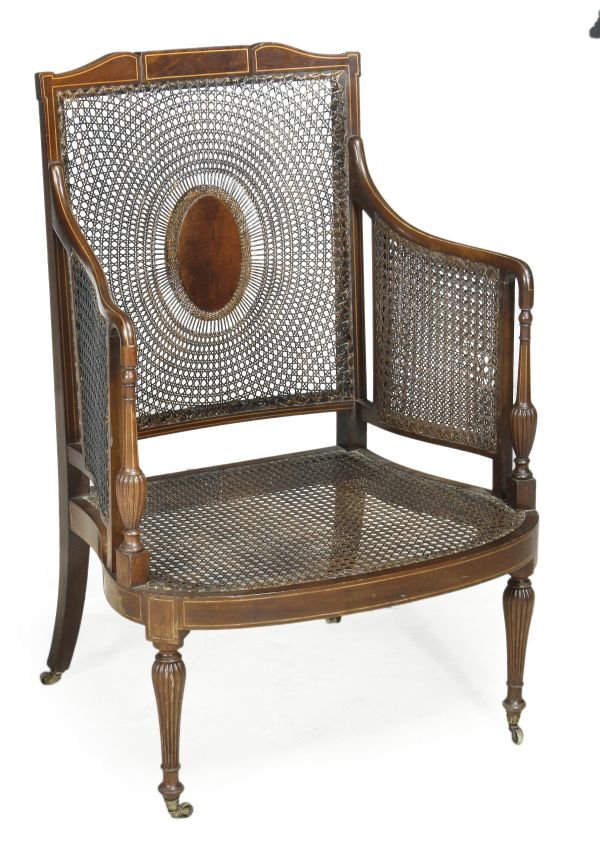 An Edwardian mahogany and satinwood bergere armcha