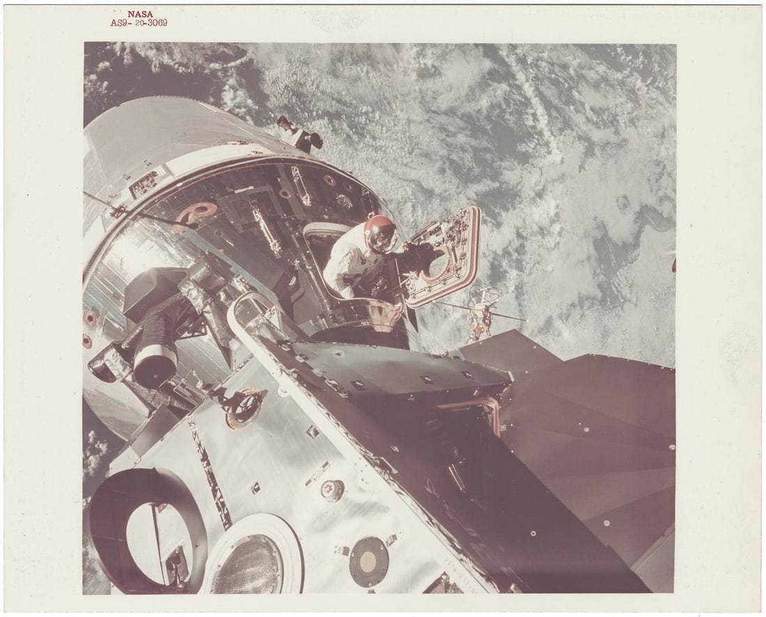 [Apollo 9] OUTER-SPACE VIEW OF DAVID SCOTT PHOTOGRAPHING FROM THE SPACECRAFT HATCH (1 of 2)