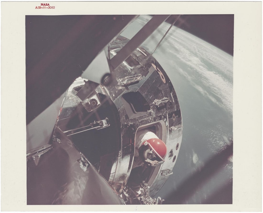 [Apollo 9] STAND-UP EVA: DAVID SCOTT EMERGING FROM CSM GUMDROP, VIEWED FROM LM SPIDER (1 of 2)