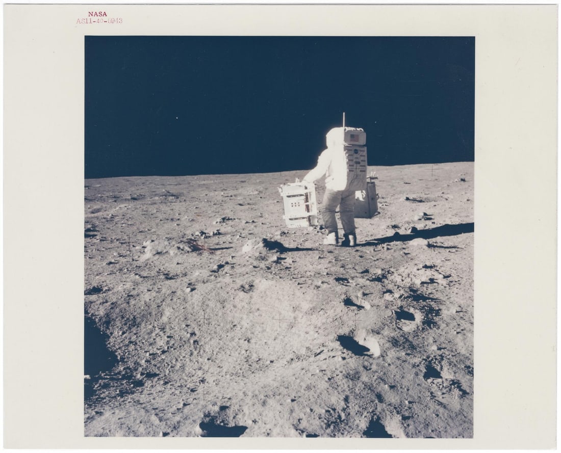 [APOLLO 11] BUZZ ALDRIN STRIDING ACROSS THE SEA OF TRANQUILITY WITH SCIENTIFIC EQUIPMENT (1 of 3)