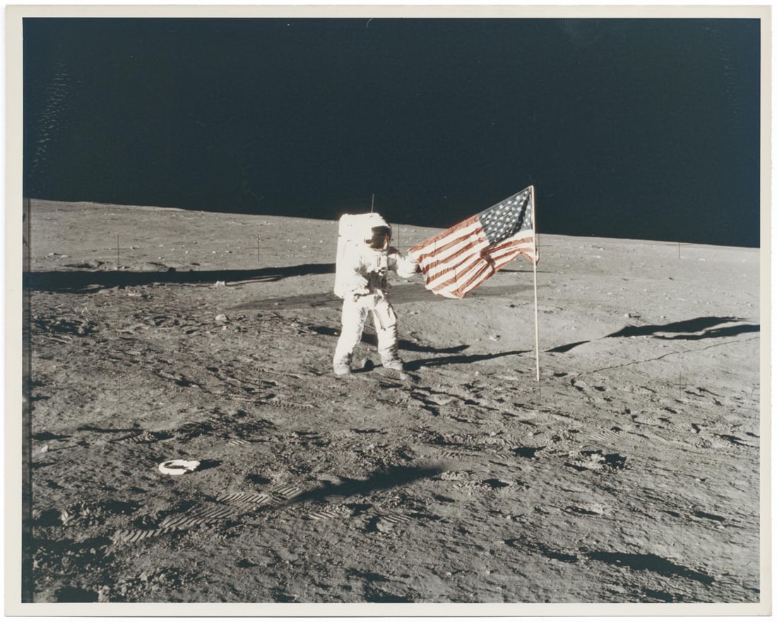 [Apollo 12] PETE CONRAD HOLDING THE U.S. FLAG ON THE OCEAN OF STORMS: [Apollo 12] PETE CONRAD HOLDING THE U.S. FLAG ON THE OCEAN OF STORMSAlan Bean, 14-24 November 1969, EVA 1 Printed 1969.Vintage chromogenic print on early resin coated Kodak paper [NASA image AS12-47-6