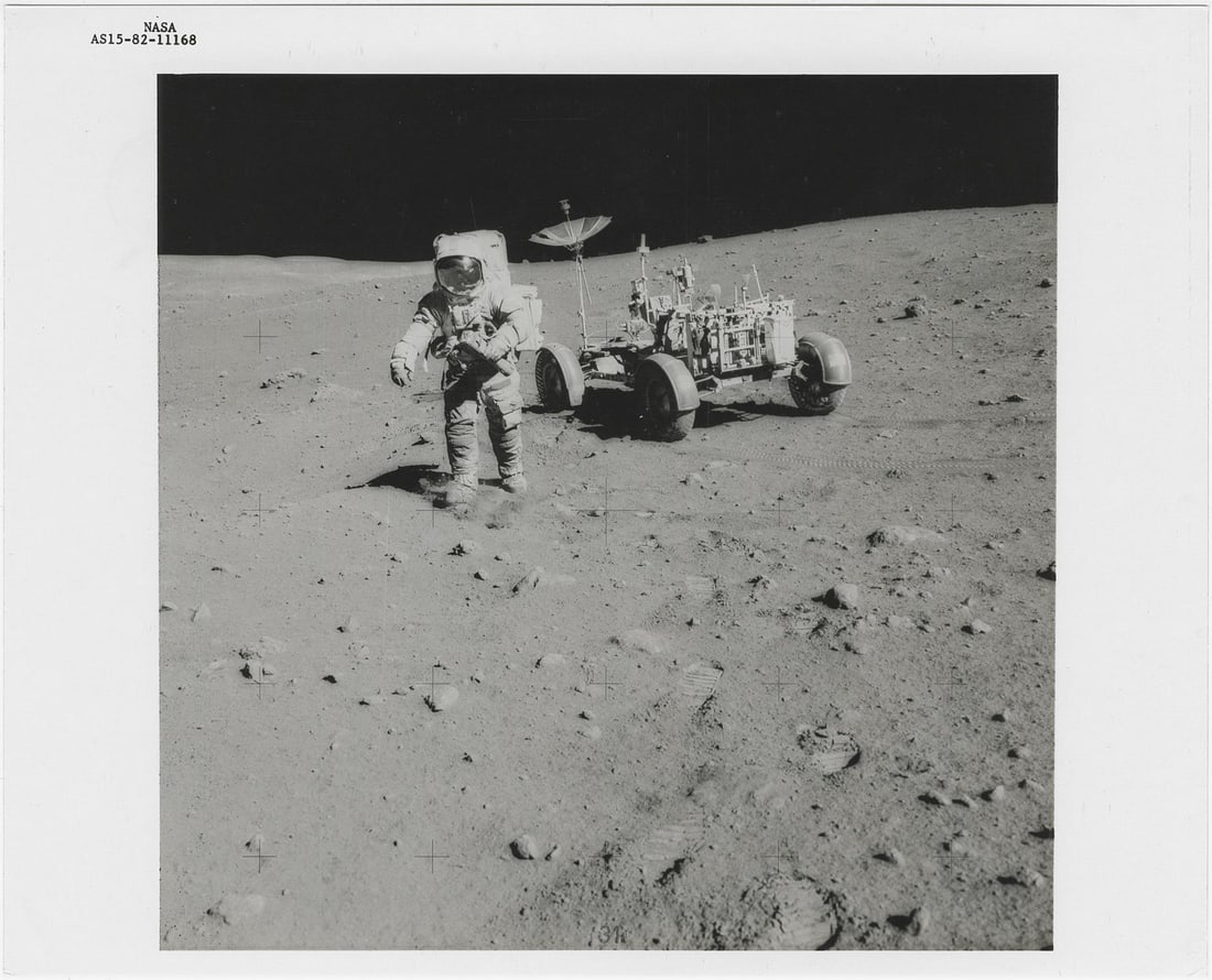 [Apollo 15] DAVID SCOTT WITH THE TELEPHOTO CAMERA AND THE LUNAR ROVER AT STATION 10 (1 of 2)