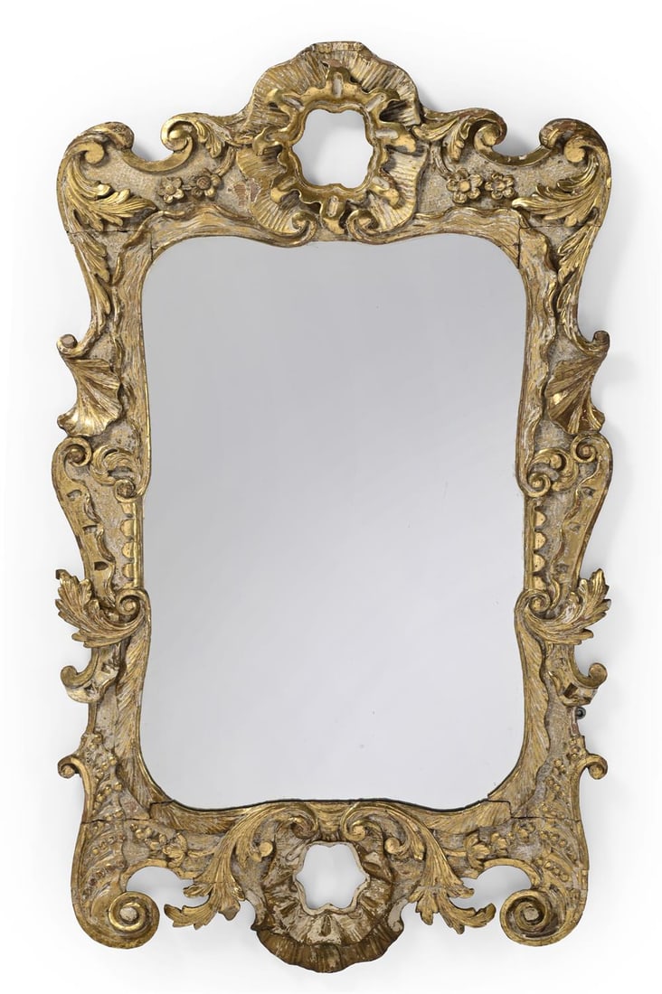 AN UNUSUAL GEORGE II CARVED GILTWOOD MIRROR, PROBABLY IRISH, IN THE MANNER OF WILLIAM KENT: AN UNUSUAL GEORGE II CARVED GILTWOOD MIRRORPROBABLY IRISH, IN THE MANNER OF WILLIAM KENT, CIRCA 1755114cm high, 64cm wide