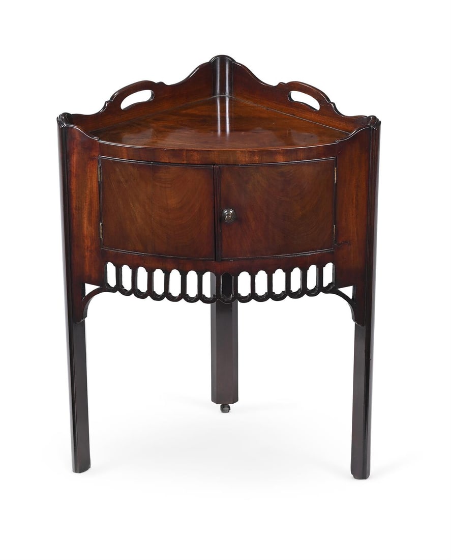 AN UNUSUAL GEORGE III MAHOGANY CORNER TABLE, IN THE MANNER OF CHIPPENDALE, CIRCA 1760: AN UNUSUAL GEORGE III MAHOGANY CORNER TABLEIN THE MANNER OF CHIPPENDALE, CIRCA 1760With a pair of cupboard doors above a pierced frieze 75.5cm high, 54cm wide, 36cm deep