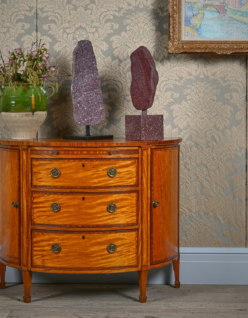 Y A GEORGE III SATINWOOD AND TULIPWOOD CROSSBANDED DEMI-LUNE COMMODE, CIRCA 1790: Y A GEORGE III SATINWOOD AND TULIPWOOD CROSSBANDED DEMI-LUNE COMMODECIRCA 1790The brushing slide with inset baize, the side doors enclosing shelves87cm high, 107cm wide, 47cm deep ϒ Indicates tha