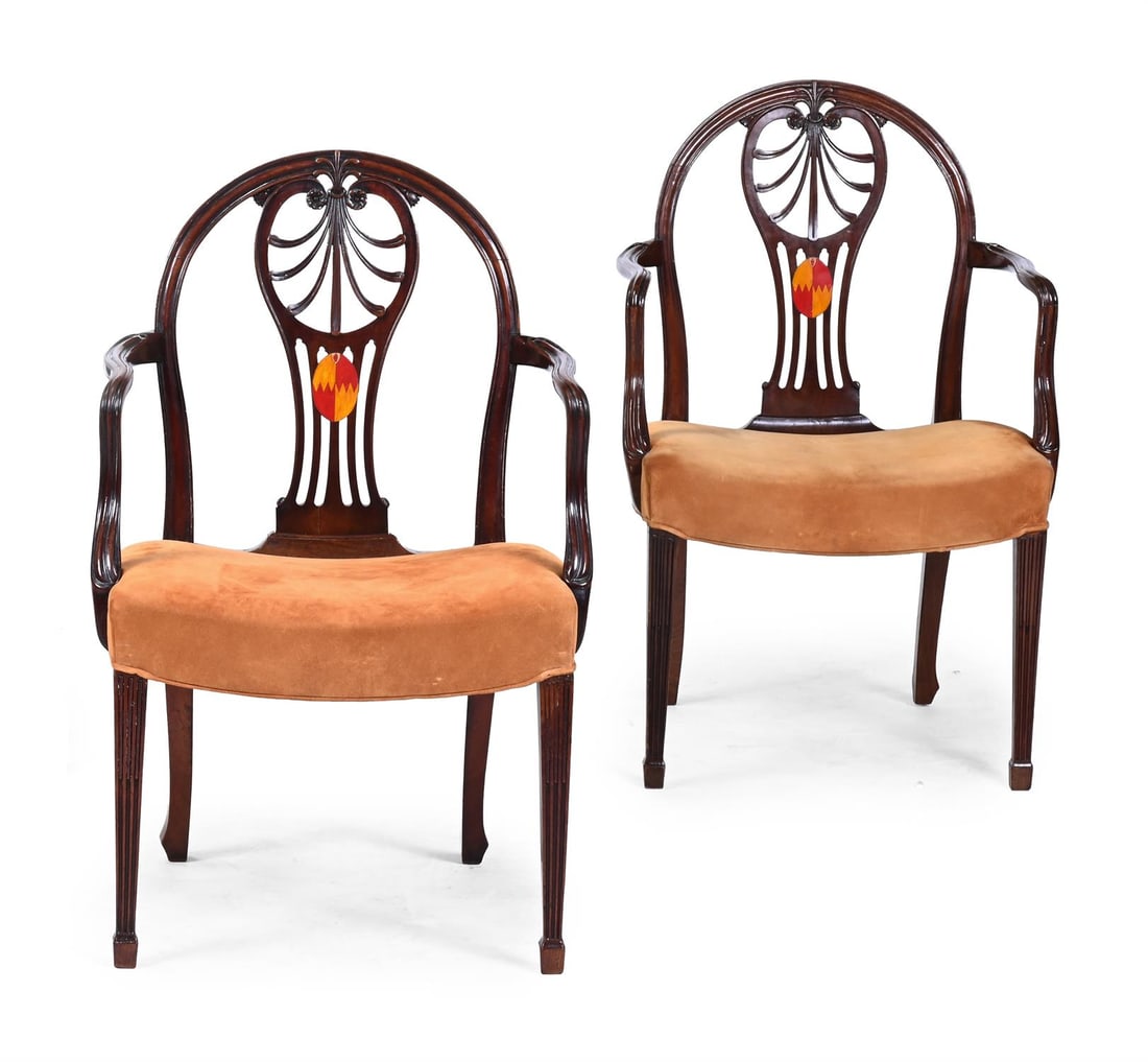 A PAIR OF GEORGE III CARVED MAHOGANY ARMCHAIRS, CIRCA 1780: A PAIR OF GEORGE III CARVED MAHOGANY ARMCHAIRSCIRCA 1780Polychrome painted with a coat of arms, the saddle seats upholstered in tan suede94cm high, 61cm wide, 54cm deep