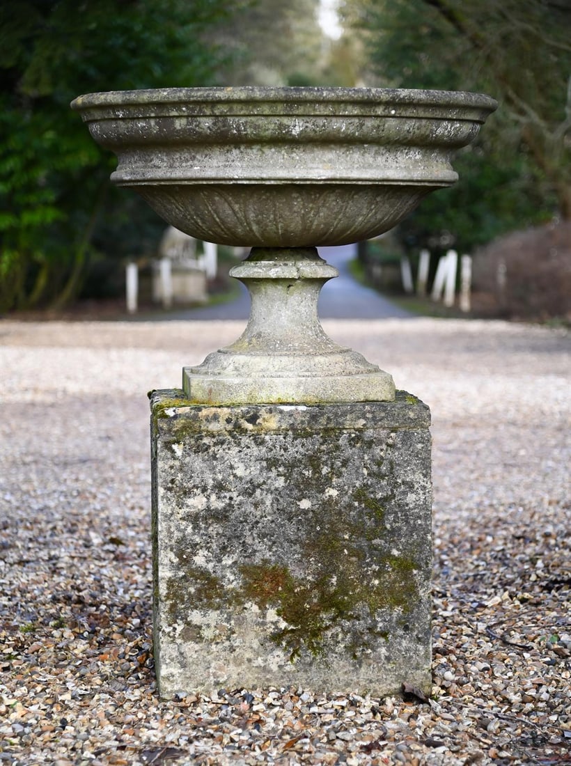 A CARVED WHITE MARBLE PEDESTAL URN OR CENTREPIECE, MID 19TH CENTURY: A CARVED WHITE MARBLE PEDESTAL URN OR CENTREPIECE MID 19TH CENTURY With stiff lotus leaf carving, set on an 18th century stone pedestal63cm high, the base 42cm square, 125cm high overall