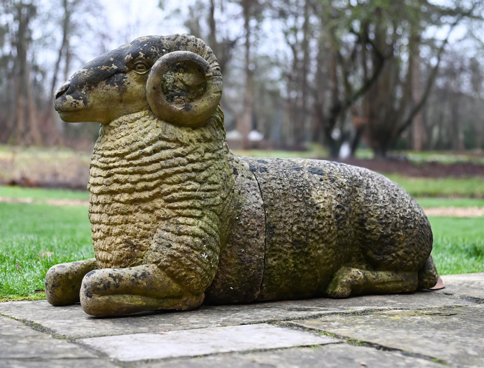 A LARGE CARVED STONE MODEL OF A RAM, 20TH CENTURY: A LARGE CARVED STONE MODEL OF A RAM20TH CENTURY57cm high, 86cm long, 36cm deep