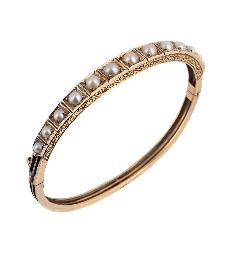 A HALF PEARL BANGLE: A HALF PEARL BANGLE The graduated half pearls to a scrolled gallery, unmarked Size/dimensions: inner width 5.5cm Gross weight: 13.2 grams Please note the pearls are untested