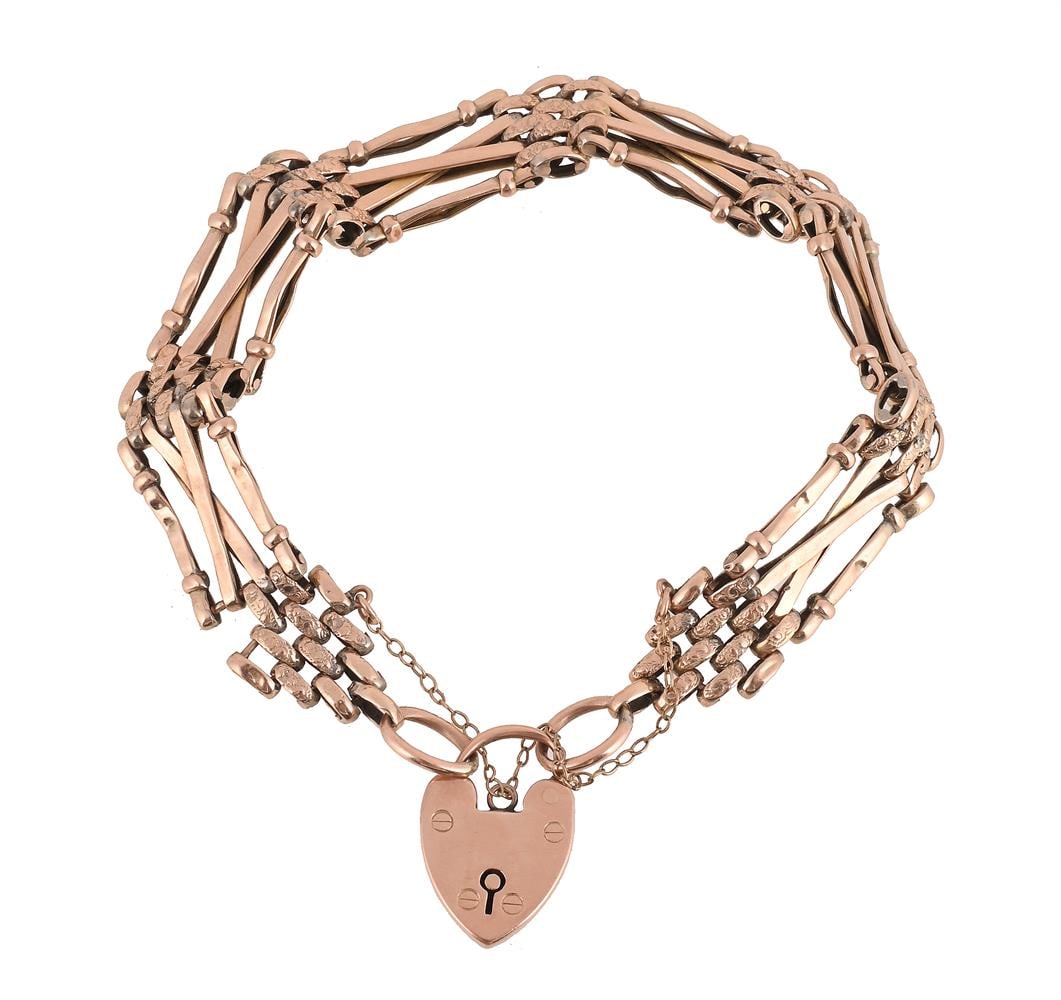 A GATE LINK BRACELET: A GATE LINK BRACELET The polished and textured bars to a heart shaped padlock clasp, stamped 9ct Size/dimensions: 20cm long Gross weight: 15.0 grams Condition