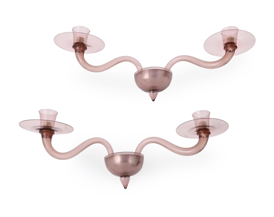 A PAIR OF MURANO TWIN-BRANCHED WALL SCONCES, FIRST HALF 20TH CENTURY: MURANO (ITALIAN)A PAIR OF TWIN-BRANCHED WALL SCONCES, FIRST HALF 20TH CENTURYPink glass, slightly iridescent surface, fixings for three branches, each with two branchesEach 78cm wide (approximately) T