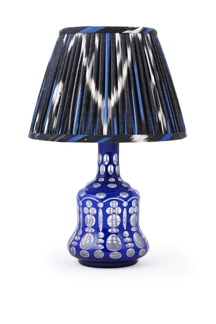 A BOHEMIAN 'HUQQA BASE' TABLE LAMP, LATE 19TH CENTURY: BOHEMIAN A HUQQA BASE TABLE LAMP, LATE 19TH CENTURYBlue and white glass overlaid and cut out of clear glass body, latterly adapted to a lamp, with Ikat fabric shade38cm high (inc. shade)