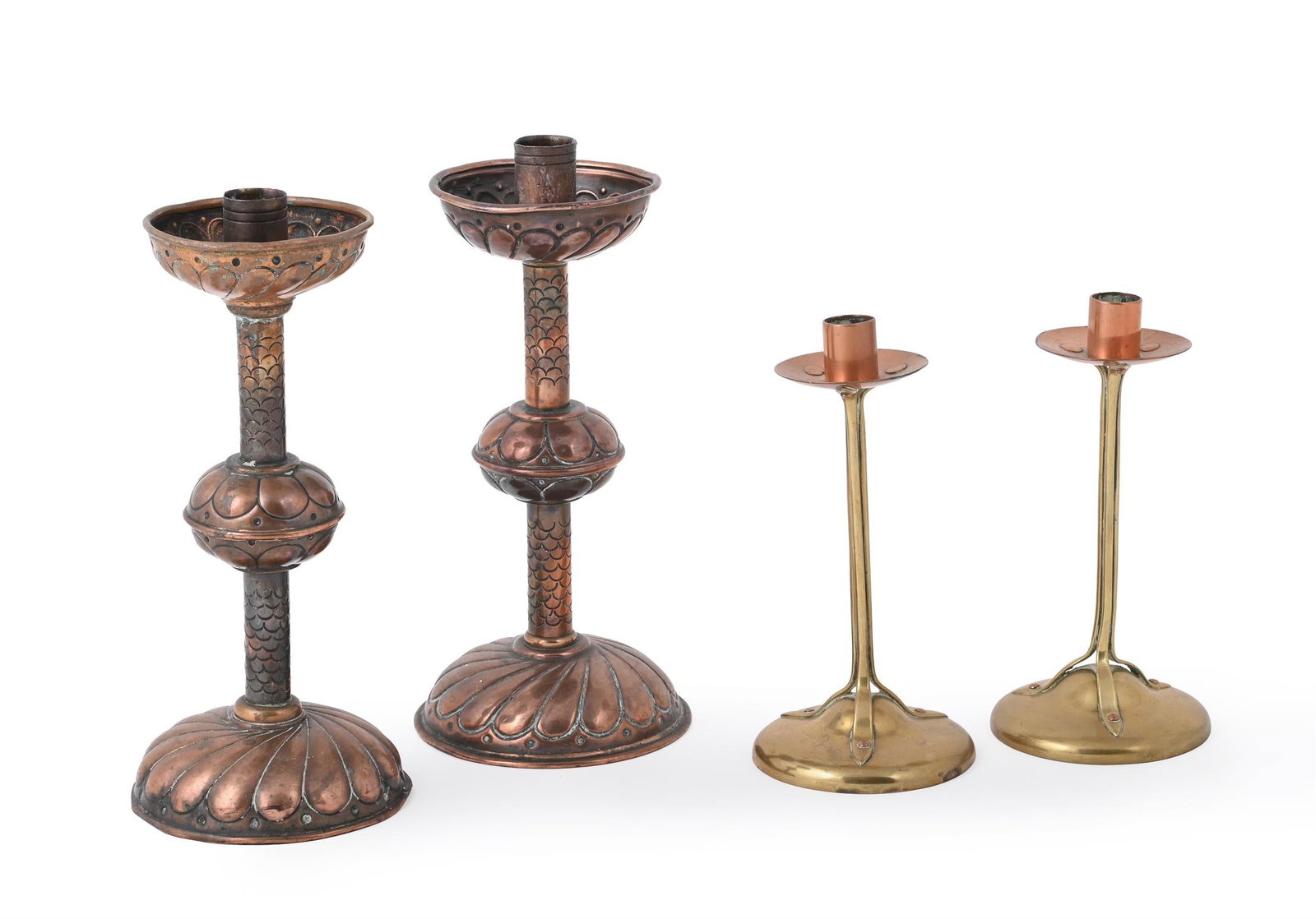 A PAIR OF AESTHETIC MOVEMENT COPPER CANDLESTICKSEARLY 20TH CENTURYStylised repoussé: ARTS & CRAFTSA PAIR OF COPPER CANDLESTICKS, EARLY 20TH CENTURYStylised repoussé decoration24cm highTogether with another pair of copper candlesticks in the Arts & Crafts style, approximately