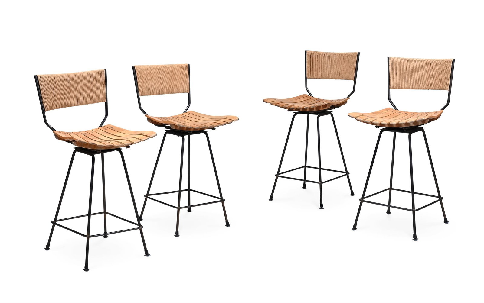 ATTRIBUTED TO ARTHUR UMANOFF (AMERICAN, 1923-1985), FOUR SWIVEL BAR STOOLS; SECOND HALF 20TH CENTURY: ATTRIBUTED TO ARTHUR UMANOFF (AMERICAN, 1923-1985)FOUR SWIVEL BAR STOOLS; SECOND HALF 20TH CENTURYPatinated iron, moulded wooden slatted seat, cord back; with swivel movement91cm high, 46.5cm wide, 46