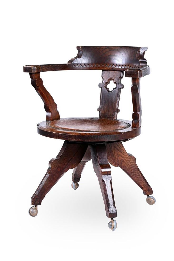 CHARLES BEVAN (BRITISH, 1815-1891), IN THE MANNER OF SWIVEL CHAIR; CIRCA 1880: CHARLES BEVAN (BRITISH, 1815-1891) IN THE MANNER OF SWIVEL CHAIR; CIRCA 1880Oak, rounded shape with pierced back, on casters Casters stamped 'ARCIHBALD KENRICK & SONS LTD, SHEPHERD PATENT, MADE IN ENG
