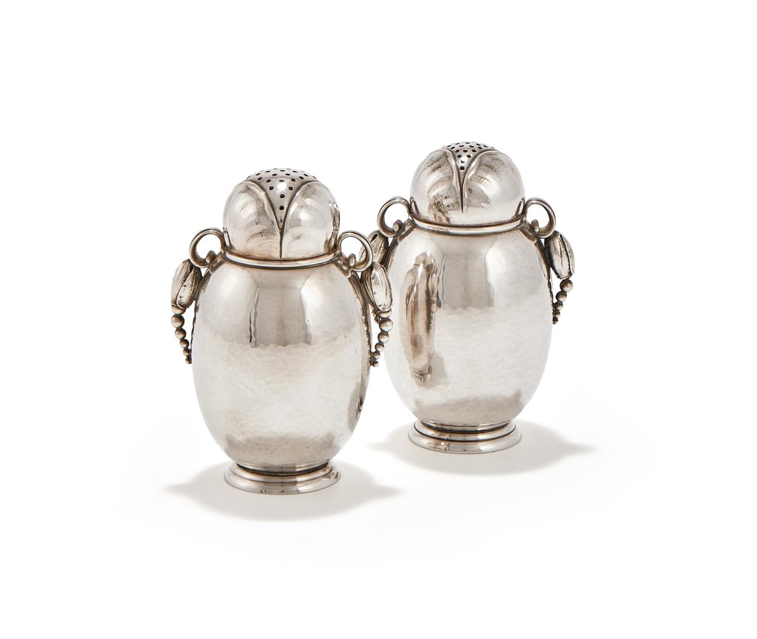 GEORG JENSEN (DANISH, 1866-1935), A PAIR OF SUGAR CASTERS, 'MODEL NO. 2A', POST 1945: GEORG JENSEN (DANISH, 1866-1935)A PAIR OF SUGAR CASTERS, 'MODEL NO. 2A', POST 1945Silver, with applied foliate 'Blossom' handlesStamped maker's marks and Danish hallmarks10.5cm high
