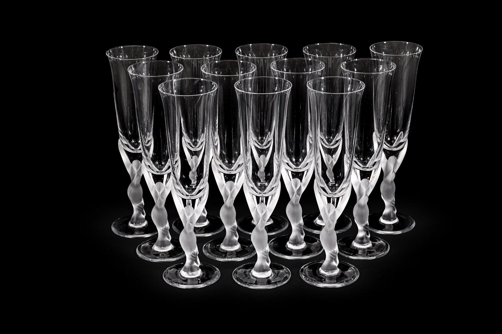 IGOR CARL FABERGÉ (RUSSIAN, 1907-1982), SET OF TWELVE ‘SNOW DOVE’ CHAMPAGNE FLUTES: IGOR CARL FABERGÉ (RUSSIAN, 1907-1982)SET OF TWELVE 'SNOW DOVE' CHAMPAGNE FLUTES; LATE 20TH CENTURYClear, frosted glass; stems modelled as two kissing dovesAcid etched 'Igor Carl Fabergé' to