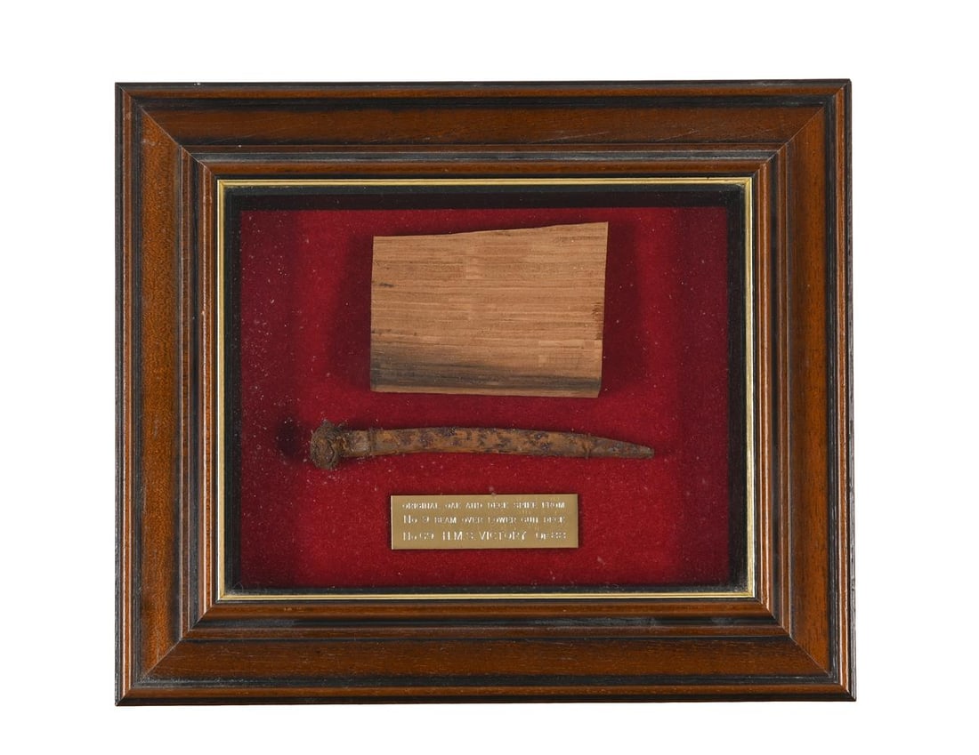 A CASED DECK SPIKE AND OAK FRAGMENT FROM H.M.S VICTORY: A CASED DECK SPIKE AND OAK FRAGMENT FROM H.M.S VICTORY The plaque bearing the legend: Original deck spike from No 9 beam, over lower deck, No 69, H.M.S Victory, of 88 30cm high, 35cm wide 