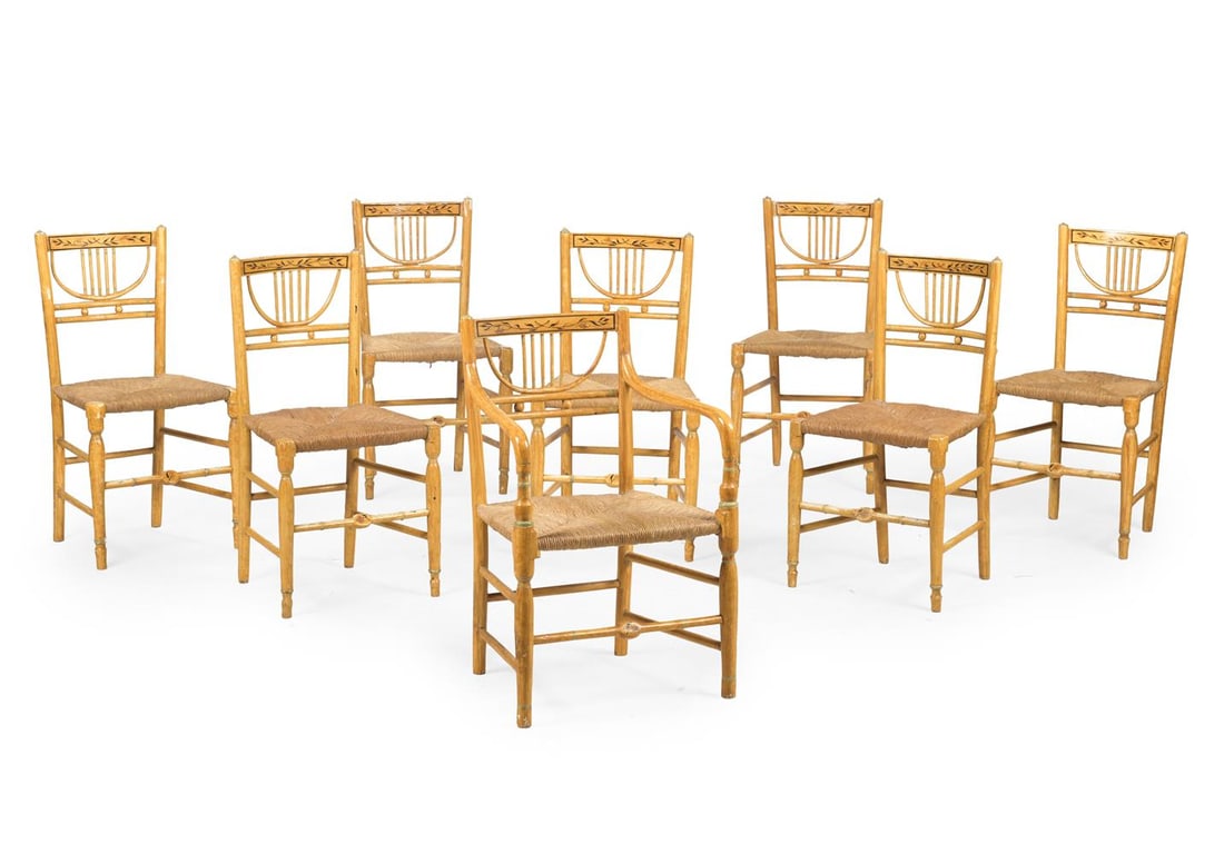 A SET OF EIGHT OCHRE PAINTED AND RUSH SEAT CHAIRS, 20TH CENTURY: A SET OF EIGHT OCHRE PAINTED AND RUSH SEAT CHAIRS 20TH CENTURY Including an armchair, each with a curved bar top rail decorated by leafy vines, and with loose cushions the chairs 85cm high, 44cm
