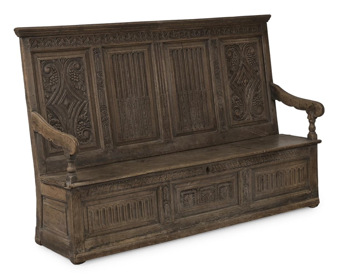 A CARVED OAK FOUR PANEL BOX SETTLE, LAST QUARTER 17TH CENTURY: A CARVED OAK FOUR PANEL BOX SETTLE LAST