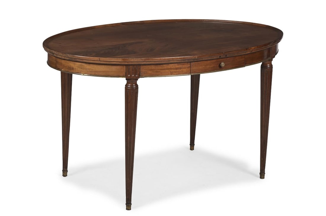 A FRENCH EMPIRE MAHOGANY DISH TOPPED OVAL TABLE, CIRCA 1814: A FRENCH EMPIRE MAHOGANY DISH TOPPED OVAL TABLE CIRCA 1814 Fitted frieze drawer to either side, with gilt metal mounts 70cm high, 127cm wide, 81cm deep Condition Report: PLEASE NOTE: ALL LOTS ARE