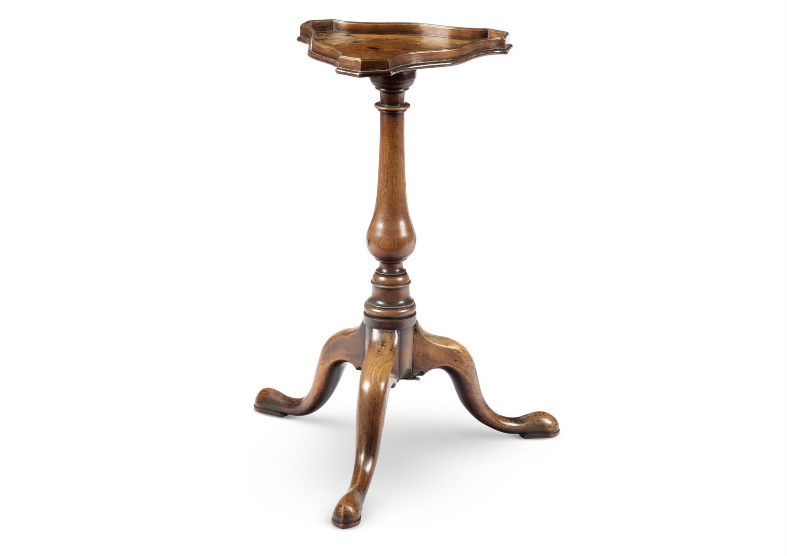 A GEORGE II MAHOGANY KETTLE STAND, MID 18TH CENTURY: A GEORGE II MAHOGANY KETTLE STANDMID 18TH CENTURYThe shaped triangular top with a low gallery on a baluster stem and tripod base with pad feet59cm high, the shaped top 29cm wideProvenance:Acquired fro