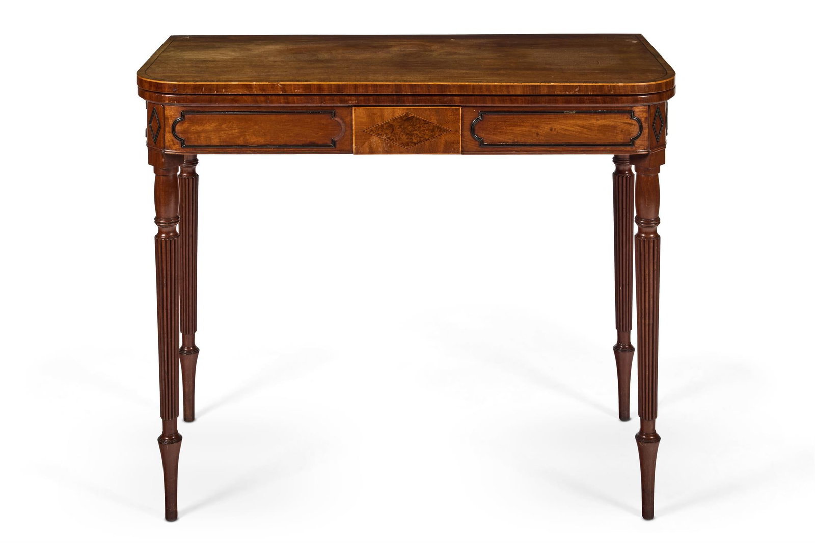 A LATE REGENCY MAHOGANY AND EBONISED GAMES TABLE, CIRCA 1820: A LATE REGENCY MAHOGANY AND EBONISED GAMES TABLECIRCA 1820The hinged baize-lined top above a panelled frieze centred by a burr yew lozenge tablet concealing a drawer on tapering turned and reeded legs