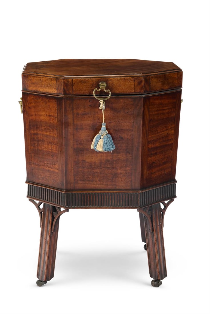 A GEORGE III MAHOGANY OCTAGONAL CELLARET, CIRCA 1770: A GEORGE III MAHOGANY OCTAGONAL CELLARETCIRCA 1770Of tapered form and with a hinged lid, with a divided interior. the fluted stand with square channeled legs and brass and leather castors65cm high, 48