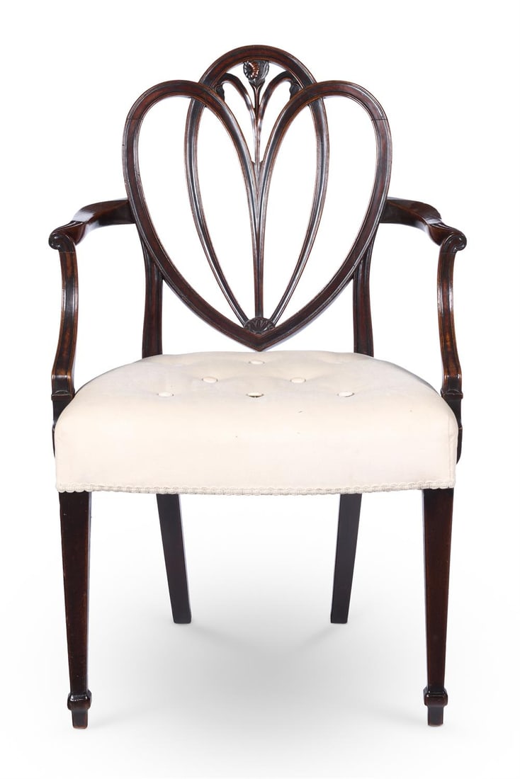 A GEORGE III MAHOGANY ARMCHAIR, CIRCA 1780: A GEORGE III MAHOGANY ARMCHAIR CIRCA 1780The interlaced heart-shaped back carved with a flowerhead and scrolled arms above a buttoned, padded seat on square tapering legs94cm high, 57cm wide, 64cm dee