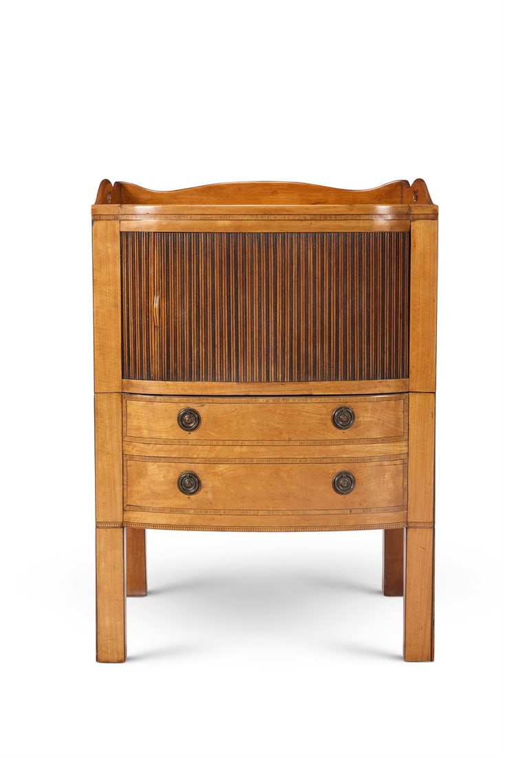 A GEORGE III SATINWOOD, MAHOGANY AND TULIPWOOD BEDSIDE COMMODE: A GEORGE III SATINWOOD, MAHOGANY AND TULIPWOOD BEDSIDE COMMODECIRCA 1770Of bowed outline and crossbanded throughout, the three-quarter gallery with pierced handles above a tambour slide, the pot drawe