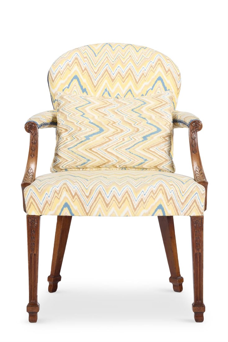 A GEORGE III MAHOGANY ARMCHAIR, CIRCA 1790: A GEORGE III MAHOGANY ARMCHAIRCIRCA 1790With a shaped padded back, the arms carved with rosettes and swags above a serpentine seat, on tapering square fluted legs93cm high, 60cm wide, 56cm deep