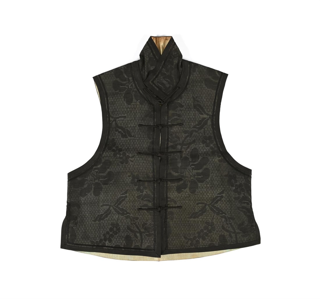 A Chinese black summer gauze waistcoat: A Chinese black summer gauze waistcoat, Qing dynasty, circa 1900, woven with large blooms and a high collar, all lined in pale blue silk, 58cm hem to collarPlease note this lot is to be sold without r