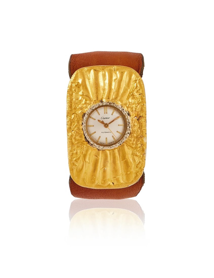 LISA SOTILIS FOR CARTIER, A DRESS WATCH: LISA SOTILIS FOR CARTIER, A DRESS WATCH CIRCA 1970 The circular silvered dial with gilt baton markers, within a broad hammered and radiating bezel, with a tapered brown leather strap and textured buck
