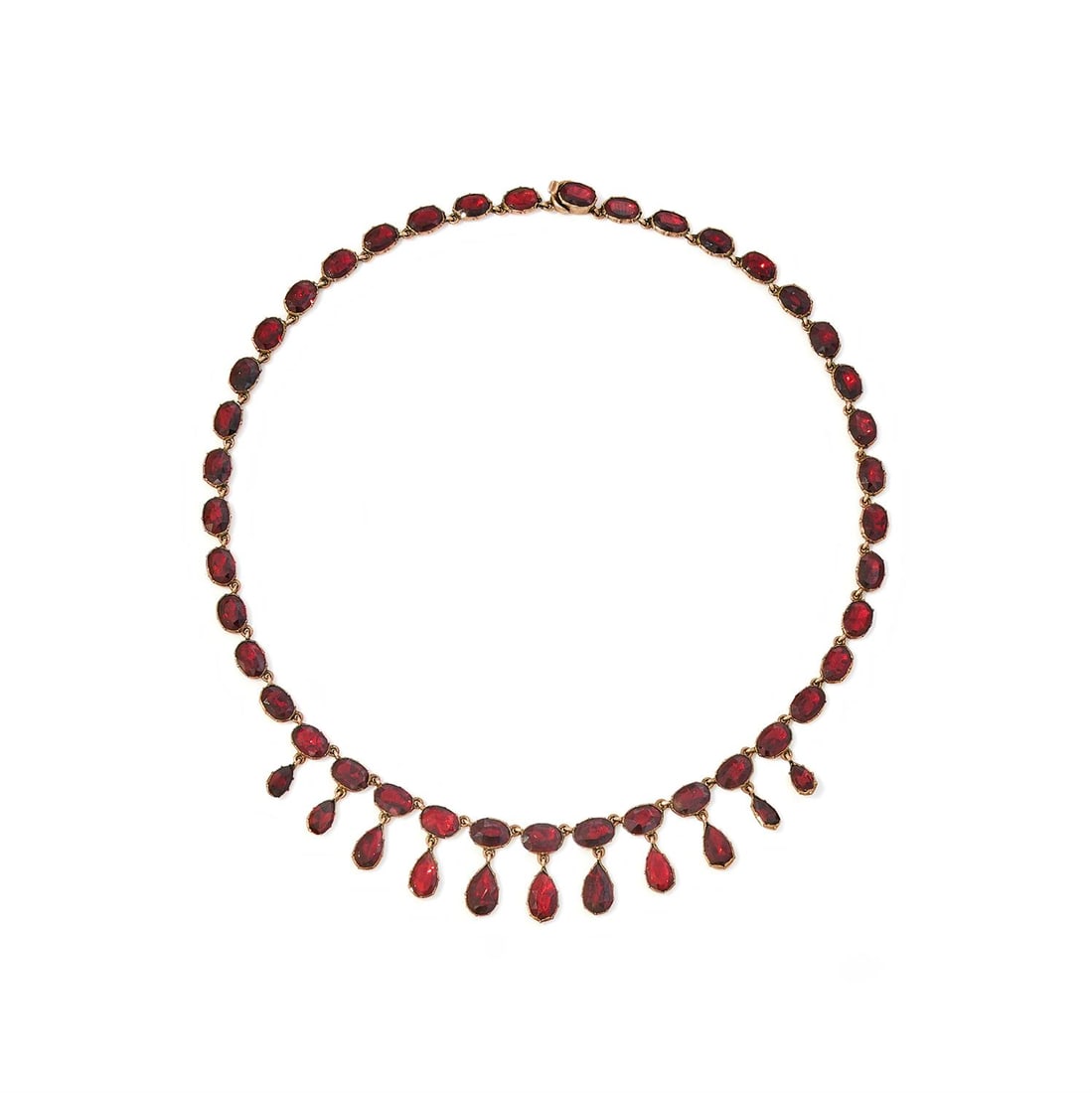 A GEORGIAN GARNET FRINGE NECKLACE: A GEORGIAN GARNET FRINGE NECKLACECIRCA 1830Composed of a continuous row of oval cut garnets in foiled closed back settings, suspending a similarly set pear-shaped garnet fringe,