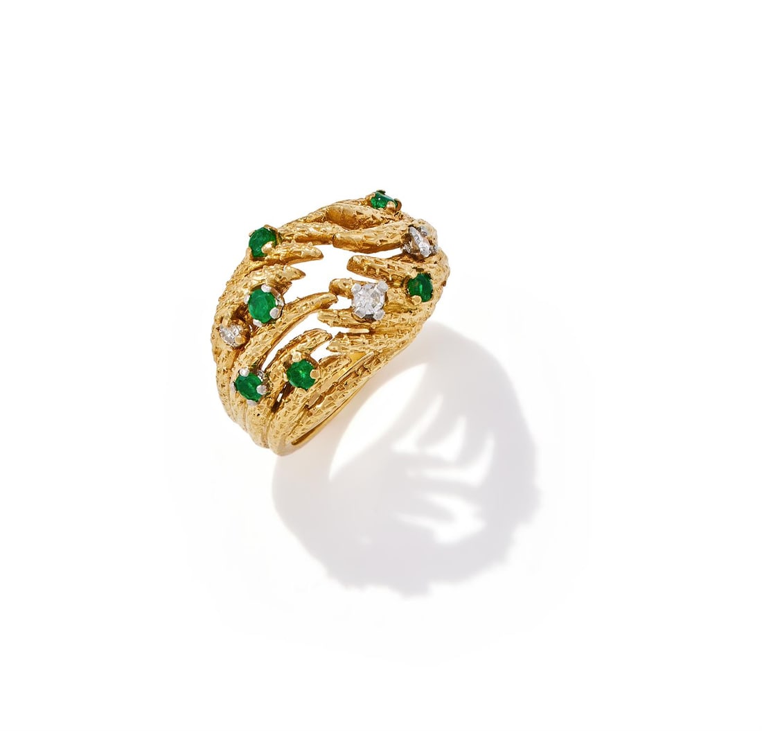 AN EMERALD AND DIAMOND DRESS RING: AN EMERALD AND DIAMOND DRESS RINGLONDON 1966Of abstract design, the 18ct gold textured tendrils accented with circular cut emeralds and diamonds, maker's mark H&M, UK hallmarkSize/dimensions: ring