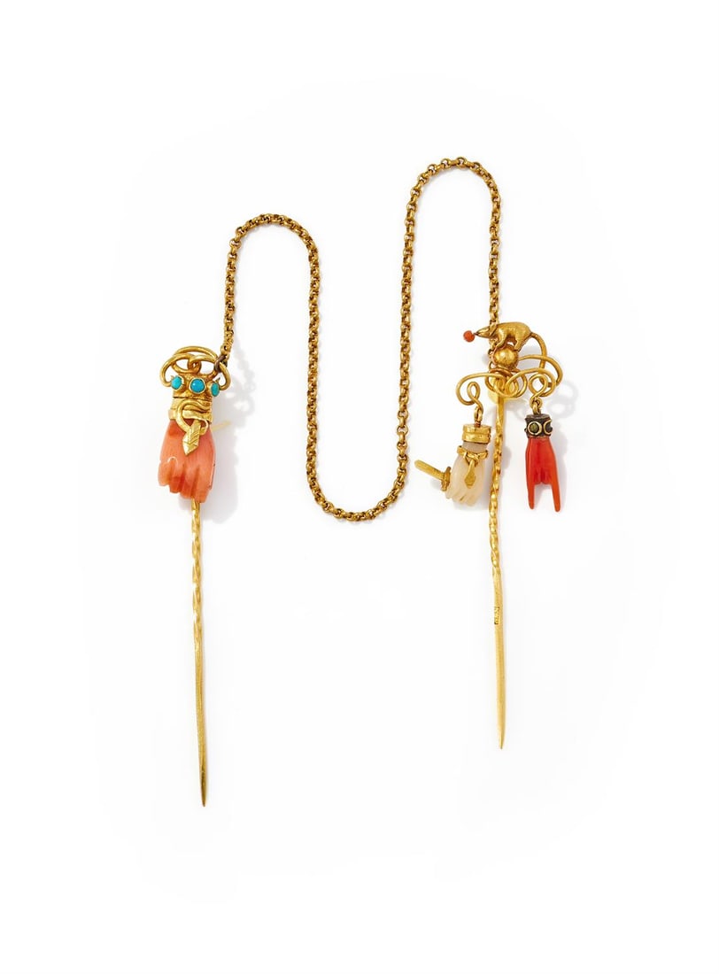 Y A 19TH CENTURY CORAL DOUBLE STICKPIN: Y A 19TH CENTURY CORAL DOUBLE STICKPIN One with a textured mouse finial with a coral bead to its nose, above a wire knot suspending traditional red and white coral charms comprising a Mano Cornuta, a