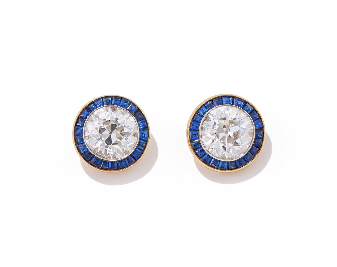 A PAIR OF DIAMOND AND SAPPHIRE EARRINGS: A PAIR OF DIAMOND AND SAPPHIRE EARRINGSEach old European cut diamond collet set within a calibré cut sapphire surround, post fittings, unmarkedSize/dimensions: 1.2cm longGross weight: 8.2 grams