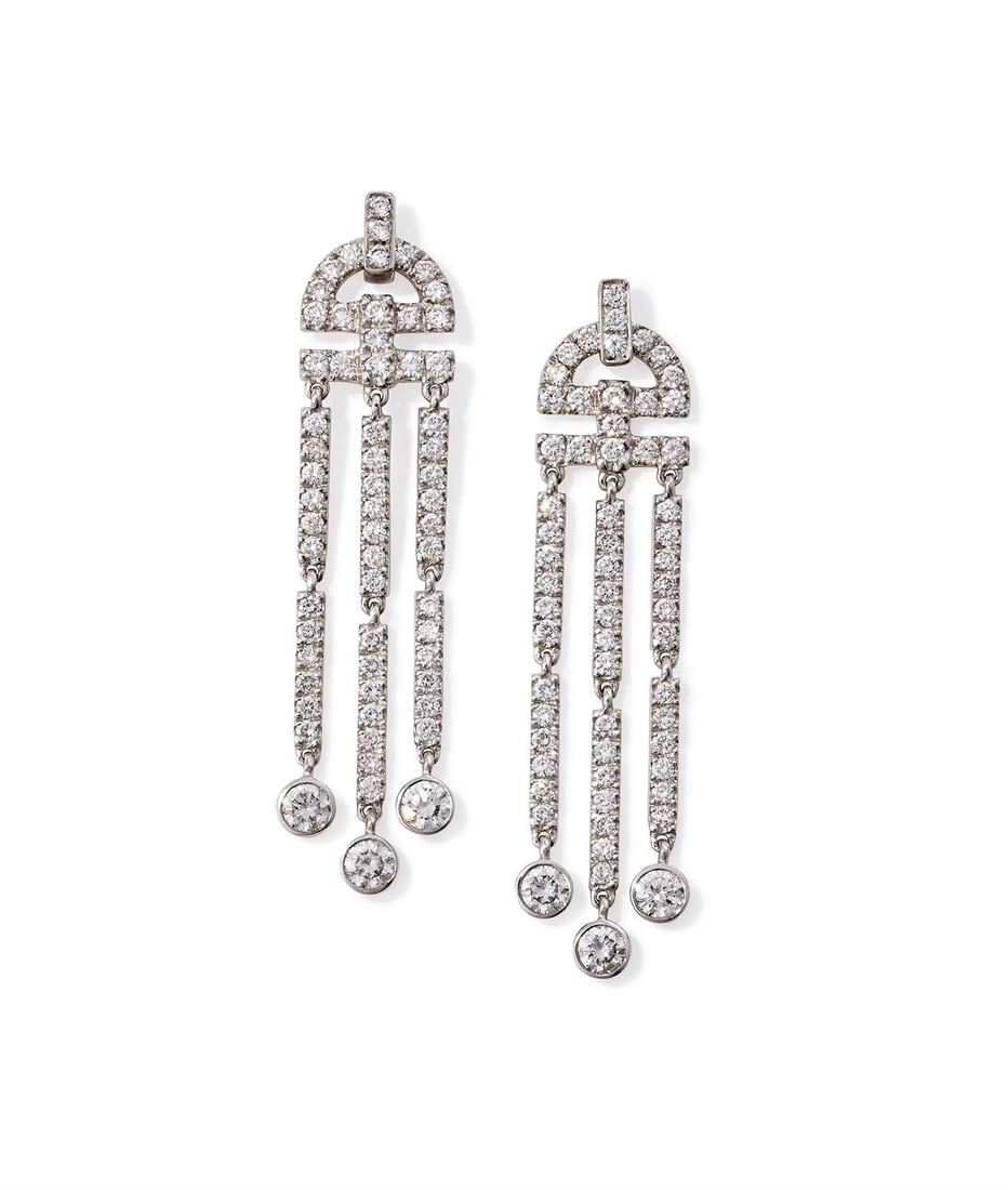 A PAIR OF DIAMOND PENDENT EARRINGS: A PAIR OF DIAMOND PENDENT EARRINGS LONDON 2004 Each openwork crescent shaped pediment suspending a trio of diamond set bars with spectacle set brilliant cut diamond drops, mounted in 18 carat white go